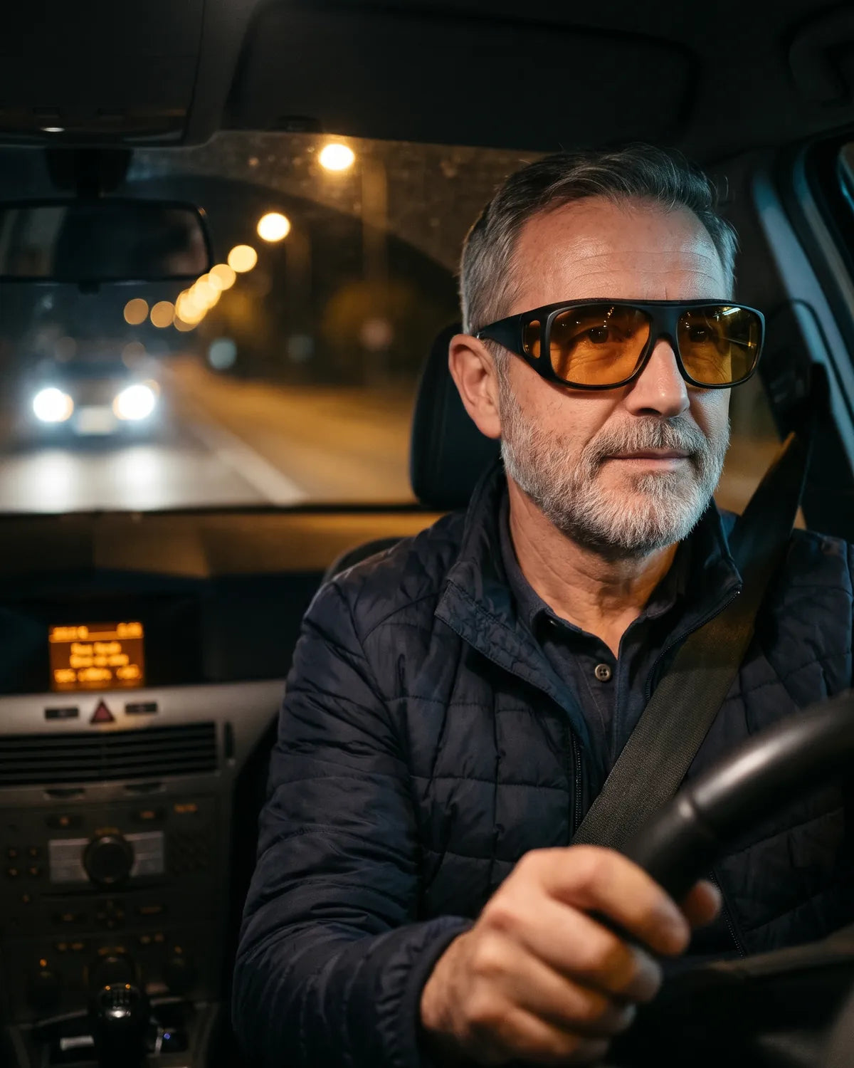Conductor de unos 60 años al volante de noche con las gafas Seredora Noche